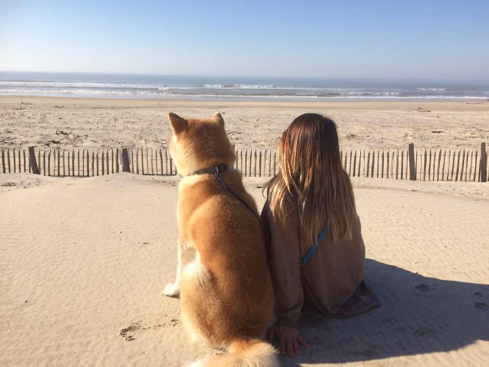 Amandine et Yoshi son Akita Roux sur la plage